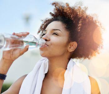 Woman Drinking Water to Stay Hydrated and Prevent Body from Overheating