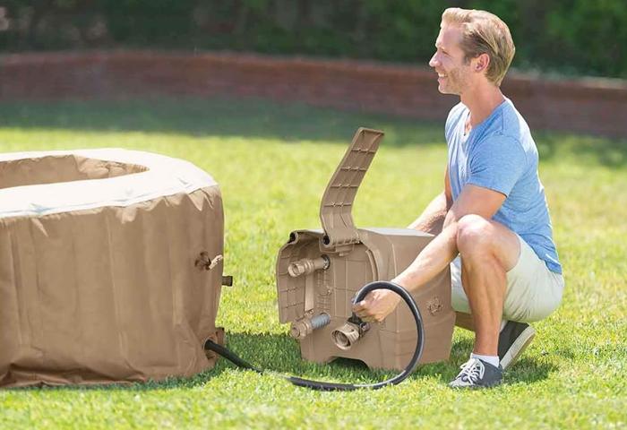 Man Setting Up Inflatable Hot Tub in Backyard on Grass